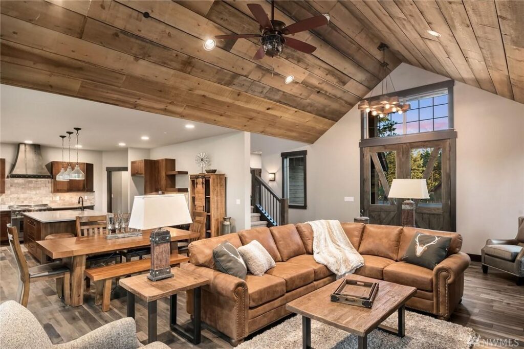 a living room filled with furniture and a wooden ceiling.