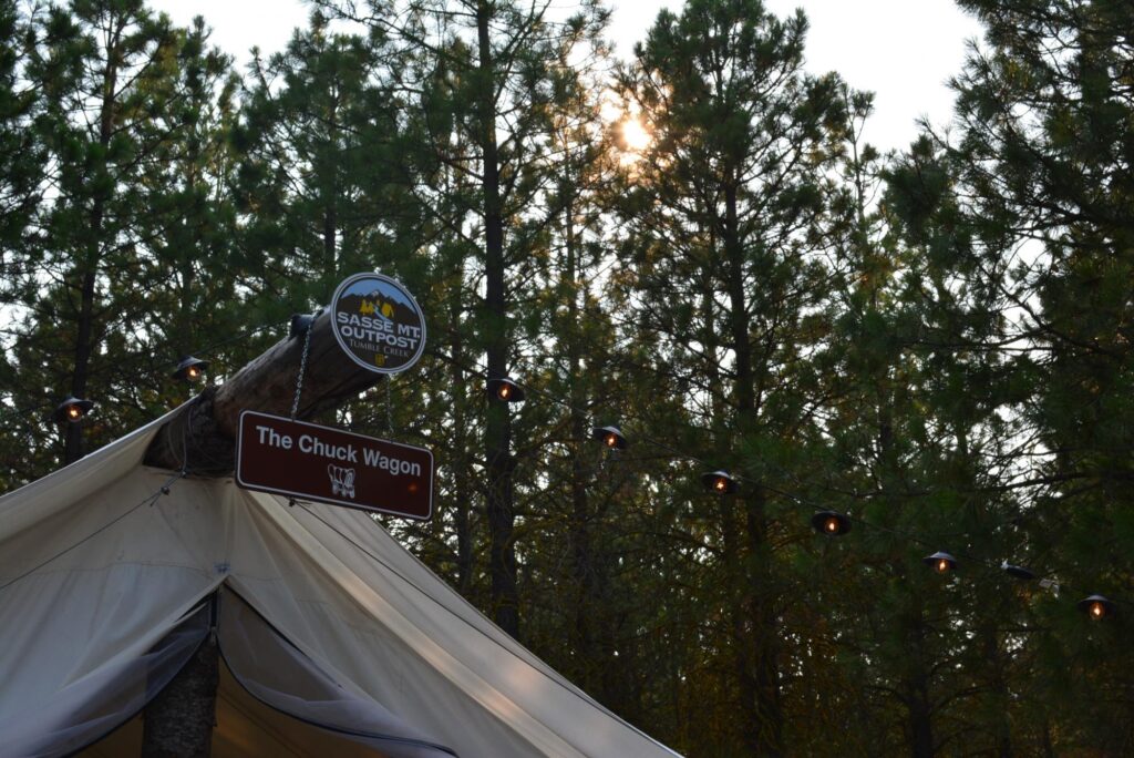 a tent with a sign on it in front of some trees.