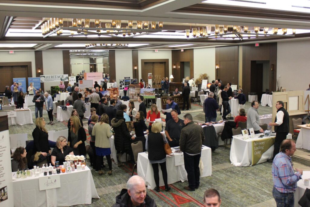 a group of people standing around tables in a room.