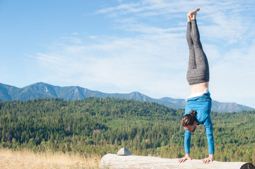 a person doing a handstand on a log.