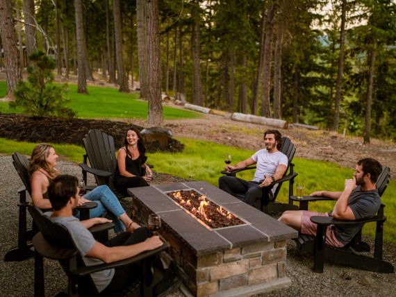 A group of friends sitting around a fire pit at a home in Suncadia Resort.